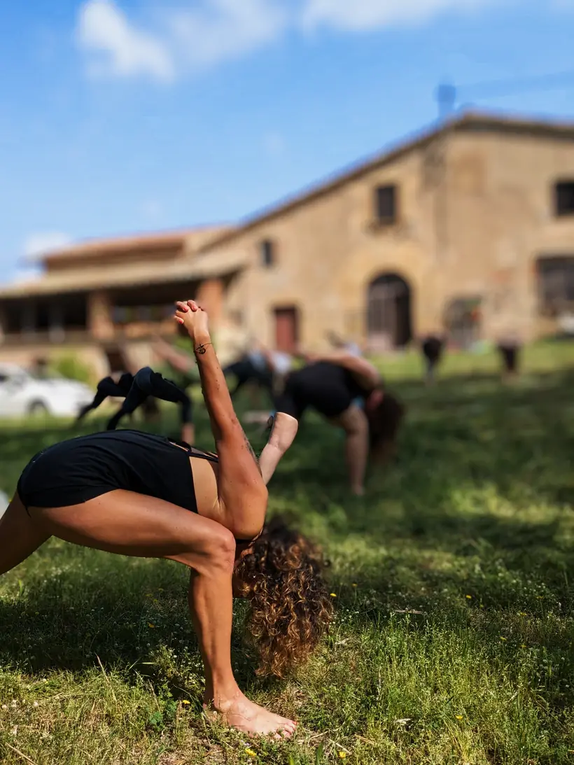 Postura de Hatha Vinyasa en el campo frente a la masía de Laranahata