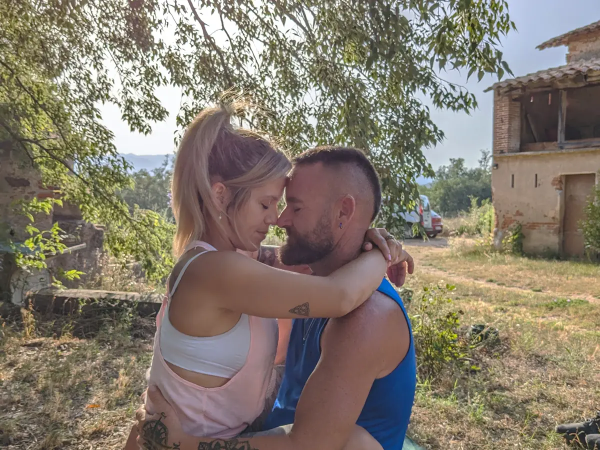 Pareja abrazada frente a la masía de Laranahata al atardecer