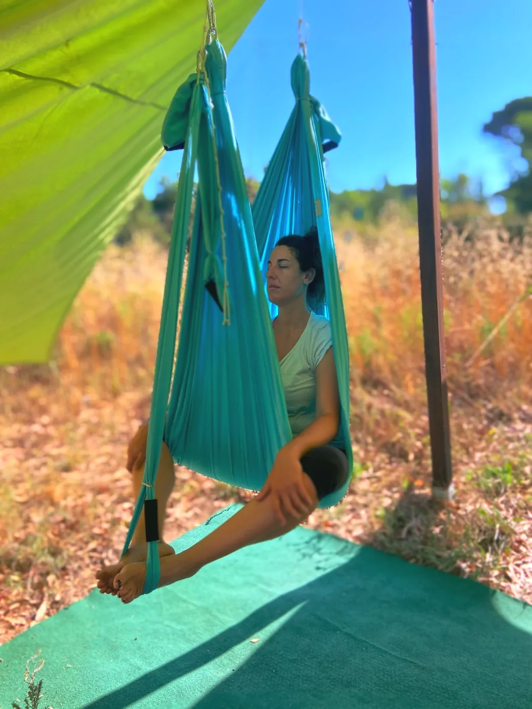 Práctica de yoga aéreo entre los árboles de la masía