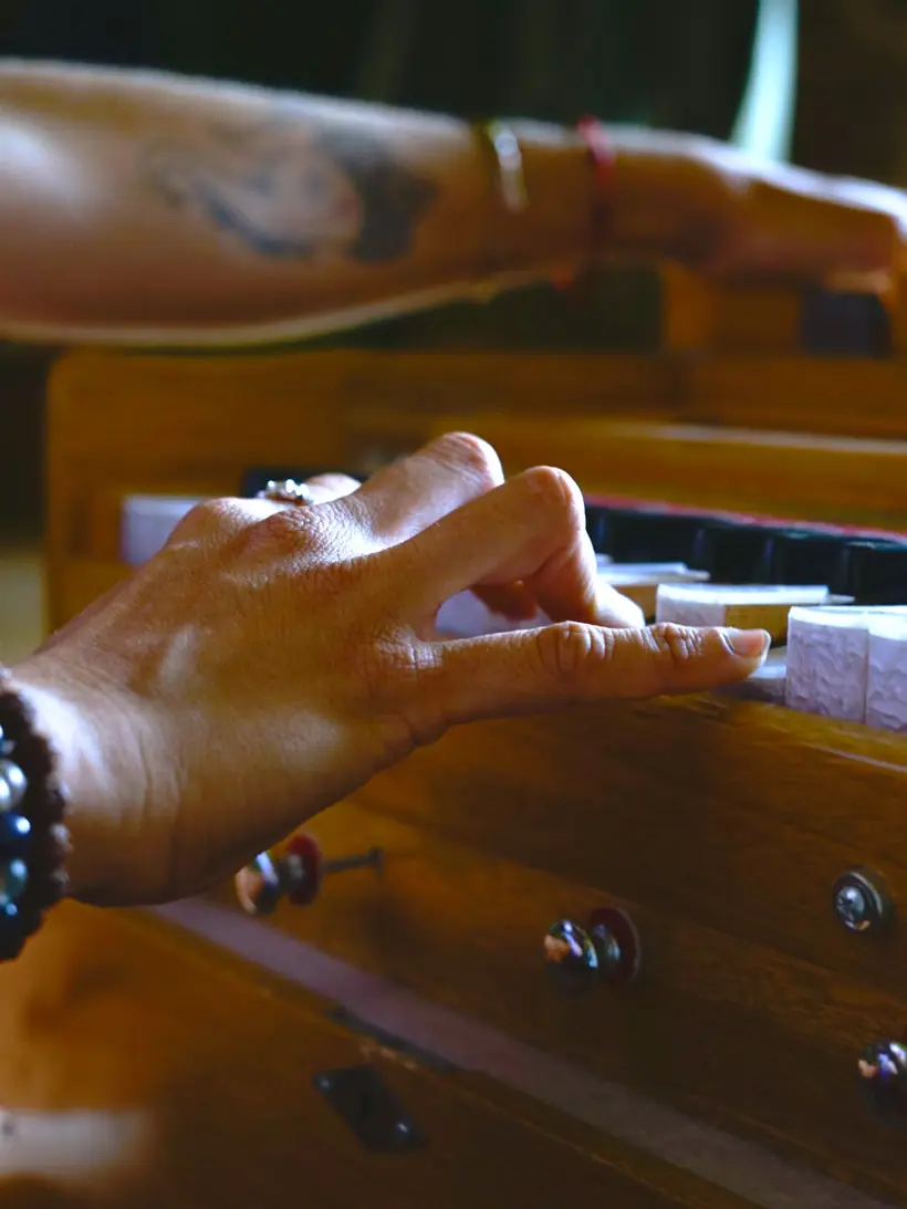 Detalle de las manos tocando el armonio durante un viaje de sonido